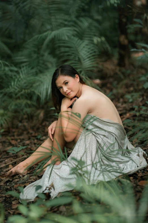 a woman sitting on the ground in the woods, a portrait, inspired by Fernando Amorsolo, unsplash, disrobed, portrait image, smooth curves, holiday season