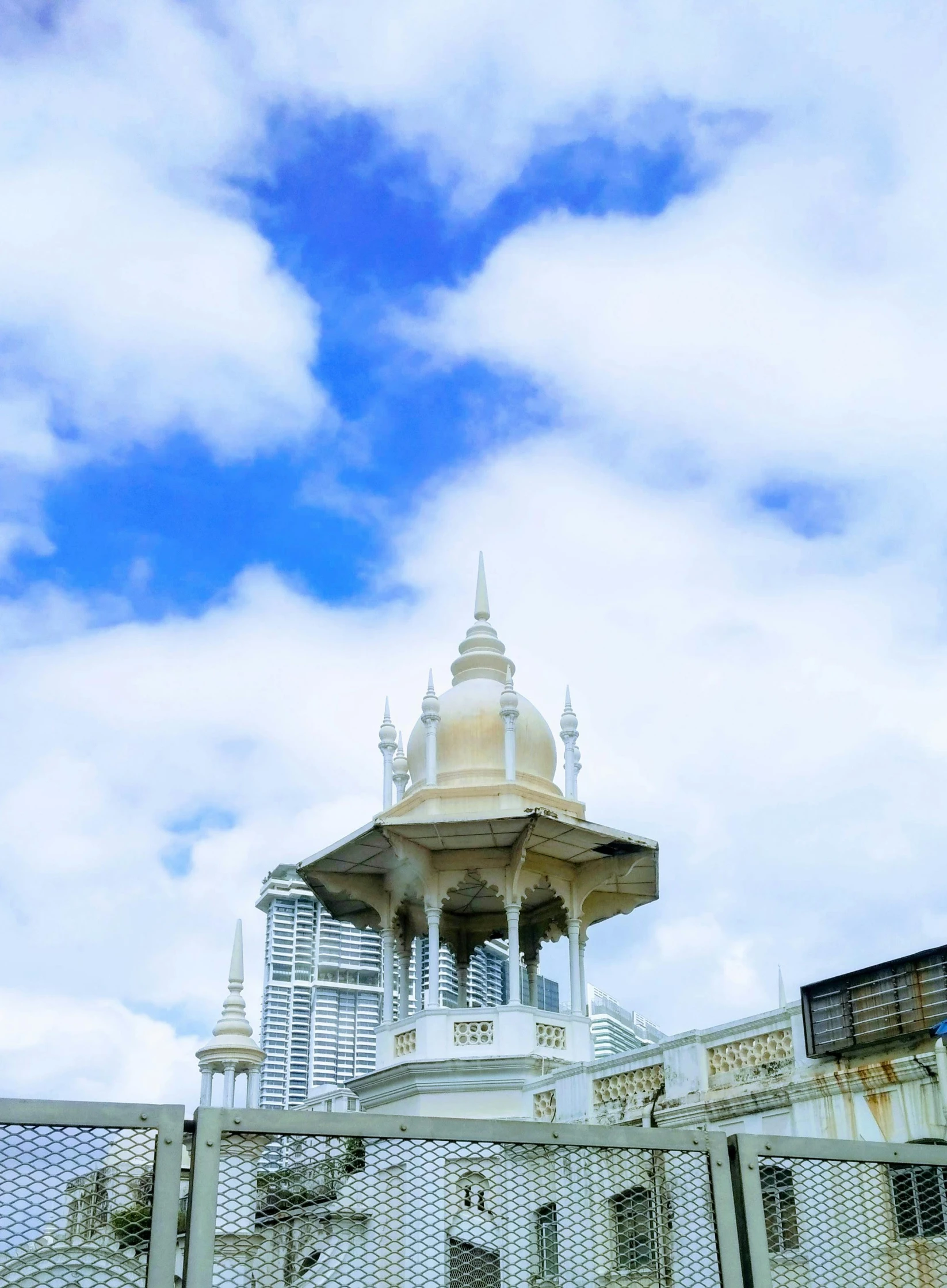 a clock tower on top of a building next to a fence, by Basuki Abdullah, in balcony of palace, kuala lumpur, profile image