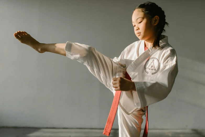 a woman in a white kimono doing a kick, pexels contest winner, wearing a red captain's uniform, youtube thumbnail, getting ready to fight, active