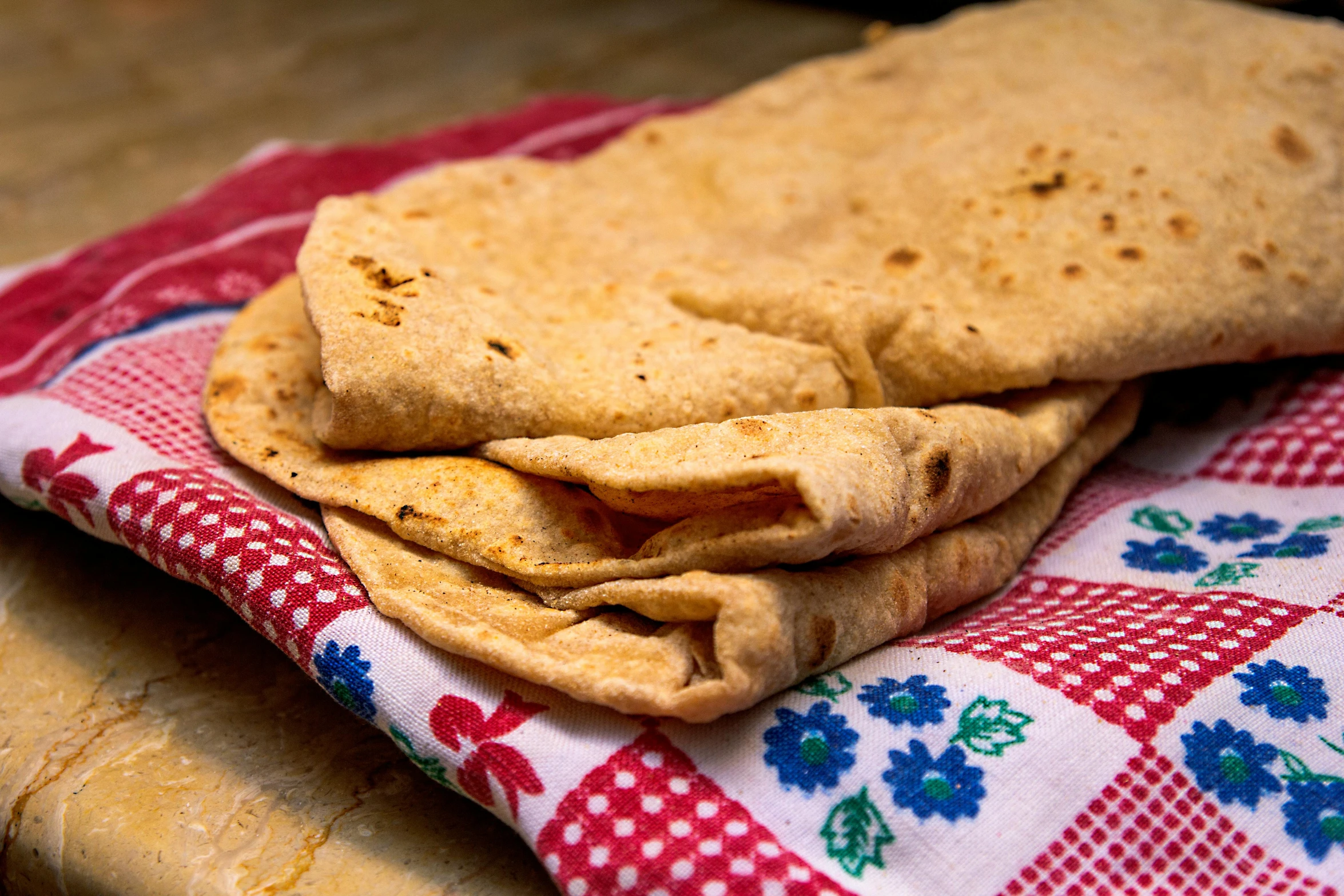 a stack of pita bread sitting on top of a red and white checkered table cloth, a portrait, flickr, portrait image