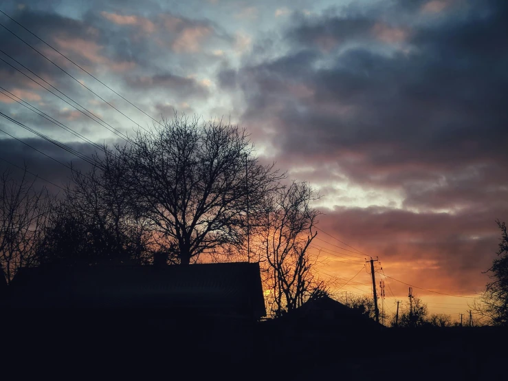 a truck parked on the side of a road under a cloudy sky, inspired by Elsa Bleda, pexels contest winner, silhouette over sunset, dark winter evening, instagram post, orange / pink sky