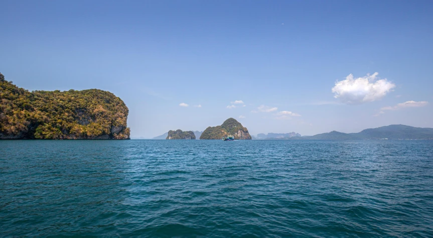 a large body of water with mountains in the background, thailand, two medium sized islands, rock arcs, high-resolution photo