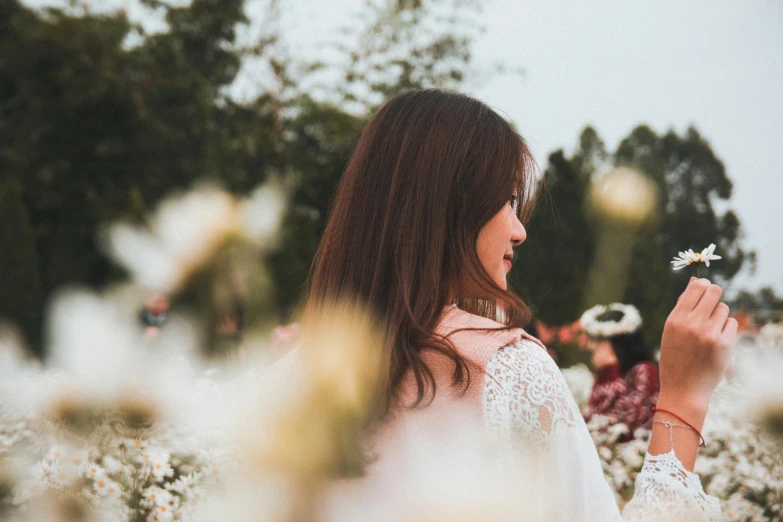 a woman standing in a field of flowers, pexels contest winner, wearing white silk, girl with dark brown hair, south east asian with long, woman's profile