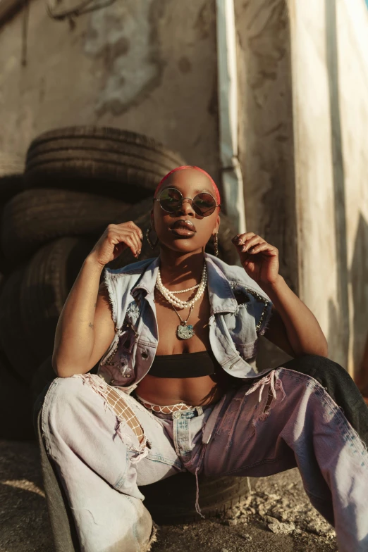 a woman sitting on the ground next to a pile of tires, an album cover, trending on pexels, afrofuturism, wearing shades, confident pose, wearing a crop top, profile image