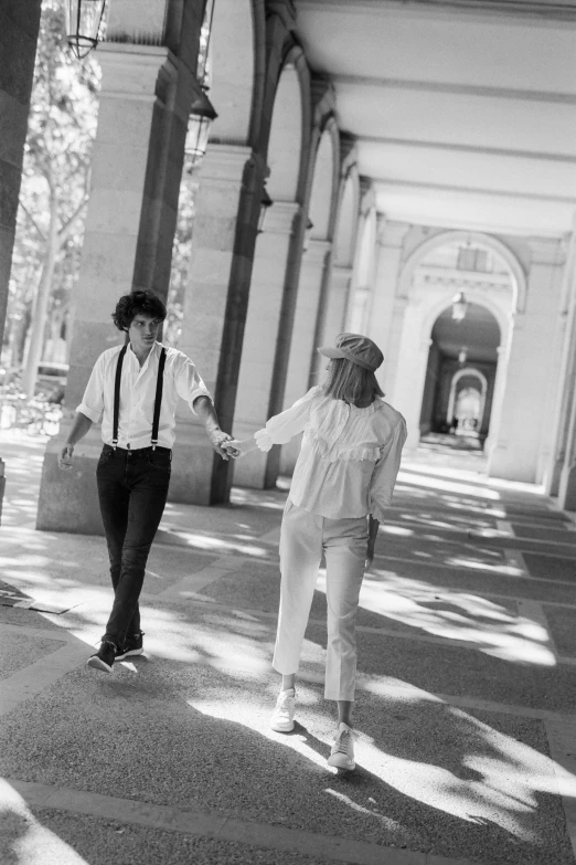 a black and white photo of a couple holding hands, inspired by Larry Fink, renaissance, hippie and boho fashion 1970s, colonnade, in a sunny day, 15081959 21121991 01012000 4k