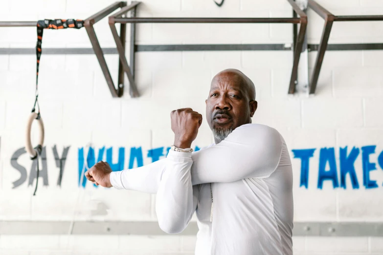 a man in a white shirt standing in a gym, by Will Ellis, dabbing, mike tyson, profile photo, rodney matthew