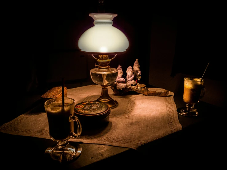 a lamp sitting on top of a table next to a cup of coffee, by Adam Marczyński, pexels contest winner, magical realism, brewing potion in witch hut, robed figures sat around a table, antique, gaslight