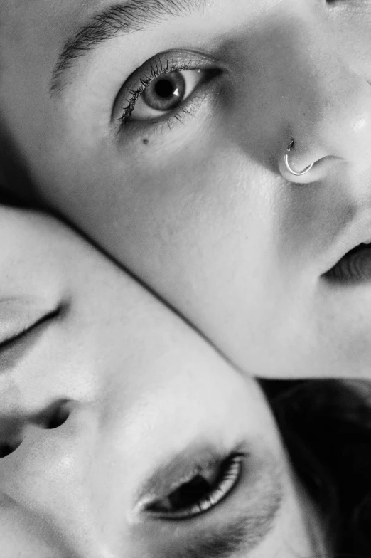 a couple of people laying on top of each other, inspired by irakli nadar, unsplash, photorealism, septum piercing, chrome facial piercings, lesbian, monochrome