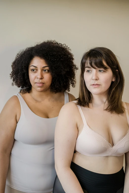 a couple of women standing next to each other, a photo, by Arabella Rankin, wearing bra, half - body composition, concerned, promotional image