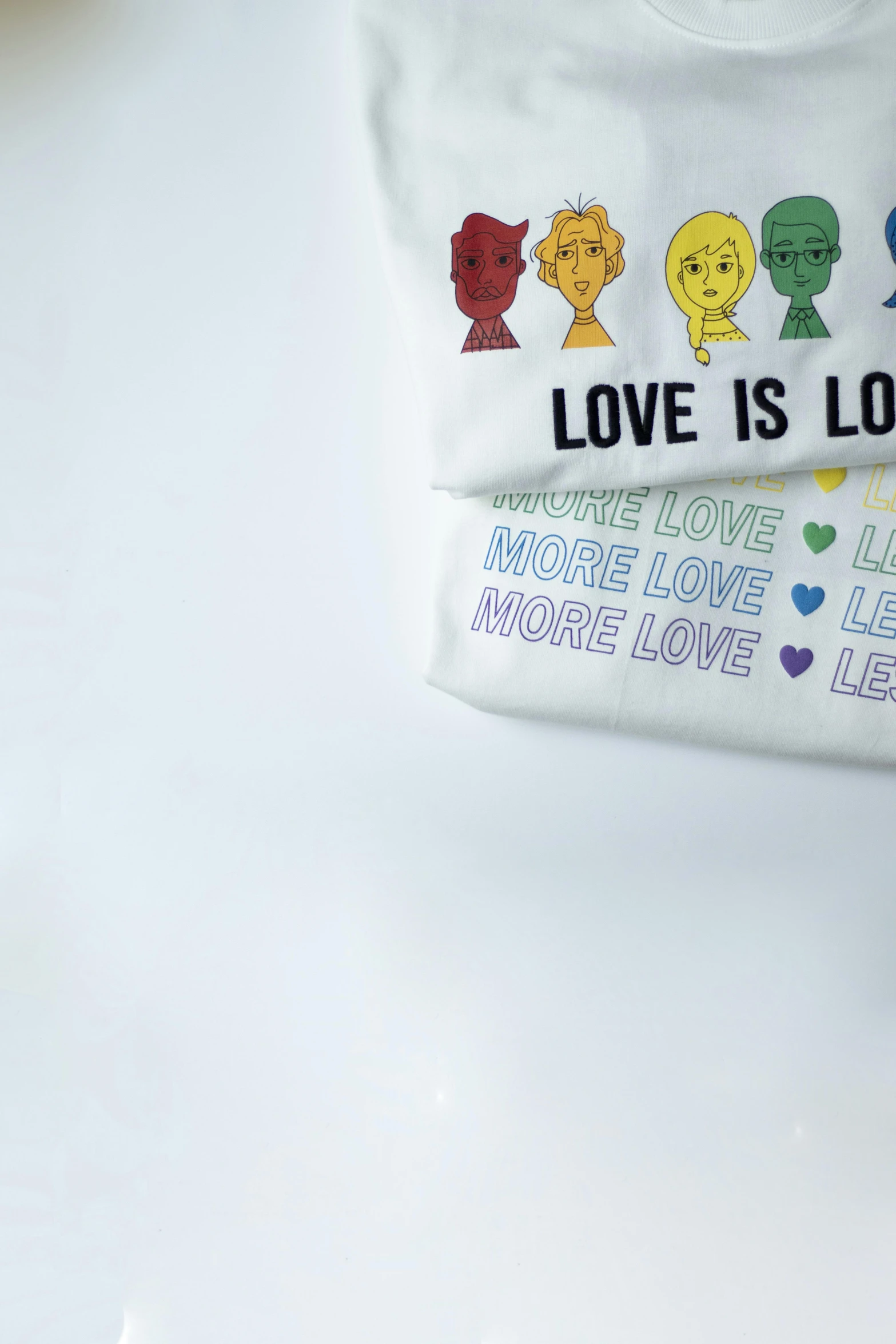 a couple of t - shirts sitting on top of a table, by Olivia Peguero, pride month, pouches, love is the most relevant theme, closeup - view