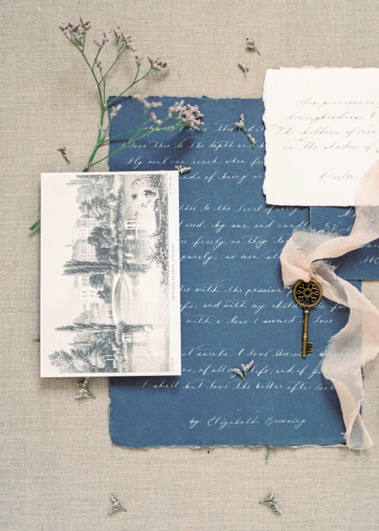 a close up of a piece of paper with a key on it, a picture, inspired by Eugène Isabey, private press, blue gray, cosy enchanted scene, invitation card, photographed on damaged film