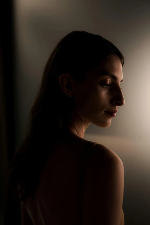 a woman standing in front of a light, soft light from the side, close up half body shot, taken with canon 5d mk4, female image in shadow