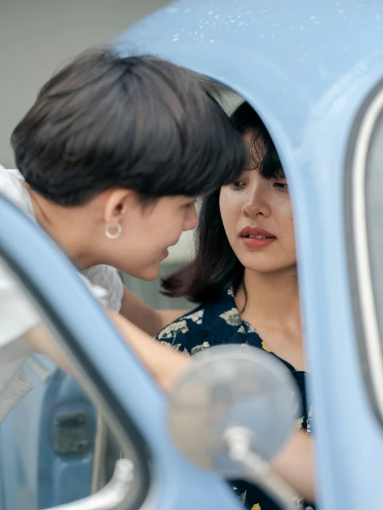 a woman standing next to a woman in a blue car, by Jang Seung-eop, trending on pexels, faces look at each other, lesbians, square, nostalgic 8k