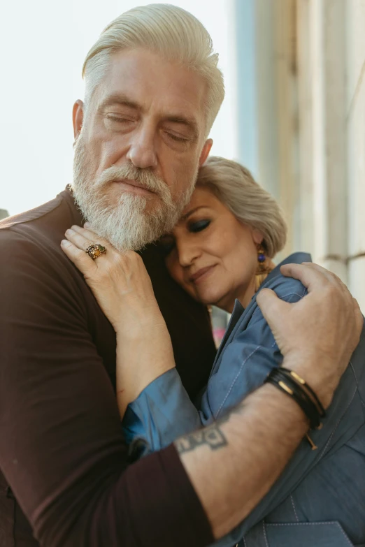 a man and woman hugging each other in front of a building, pexels, renaissance, gray hair and beard, mourning family, mature male, “diamonds