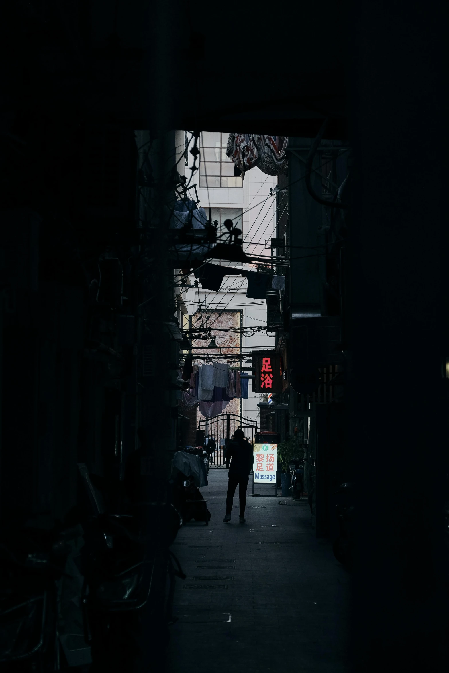 a person walking down a dark alley way, seoul, wires hanging above street, in the center of the image, shanghai