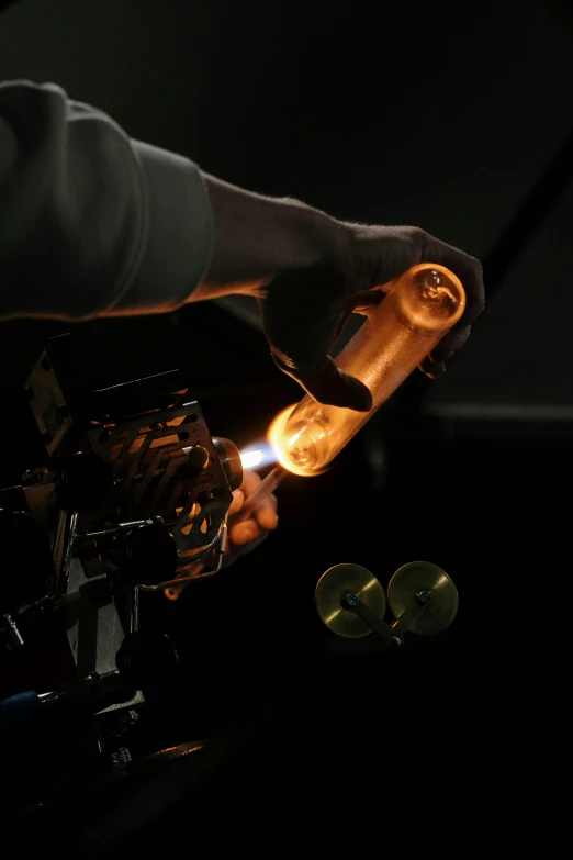 a close up of a person pouring something into a bottle, a hologram, by David Simpson, kinetic art, carbide lamp, photographed for reuters, glass bulbs, engraving