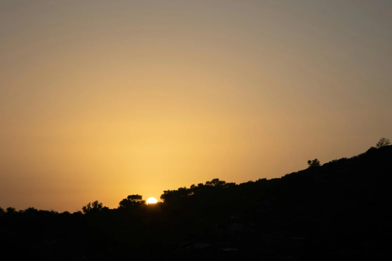 a person flying a kite on top of a hill, by Alexis Grimou, pexels contest winner, romanticism, silhouette over sunset, seen from a distance, two suns, marbella landscape