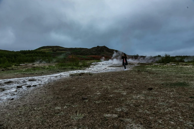 a person standing on top of a dirt field, by Hallsteinn Sigurðsson, people walking around, boiling, background image, low ultrawide shot