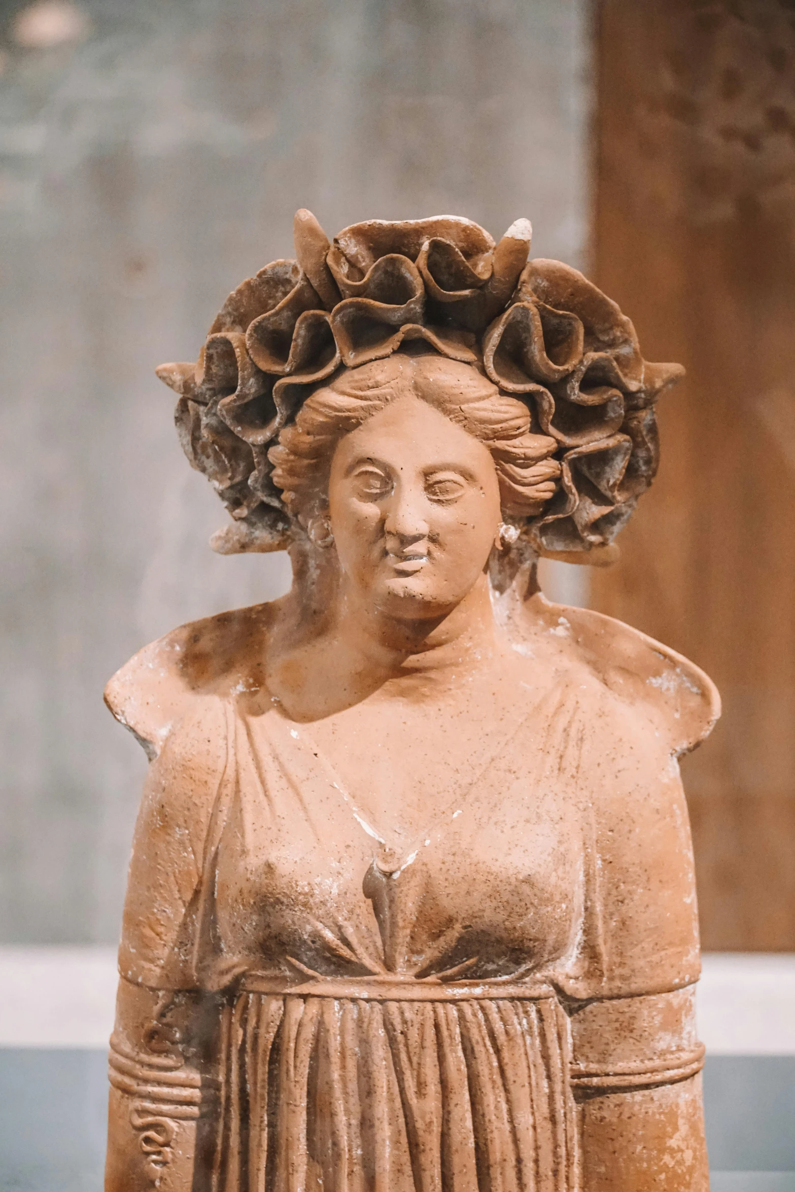 a statue of a woman with a flower in her hair, a statue, inspired by Romano Vio, coral headdress, with horns, terracotta, like in museum