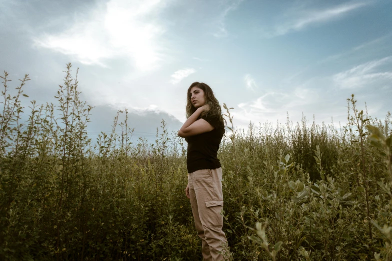 a woman standing in a field of tall grass, pexels contest winner, crossed arms, avatar image, wide angle full body, profile image
