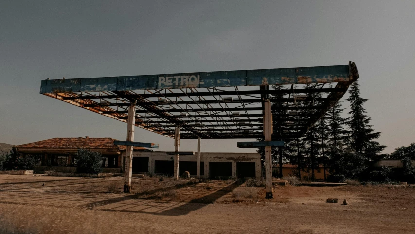 an abandoned gas station sitting in the middle of nowhere, an album cover, pexels contest winner, brutalism, petrol energy, canopies, rust, 2 0 0 0's photo