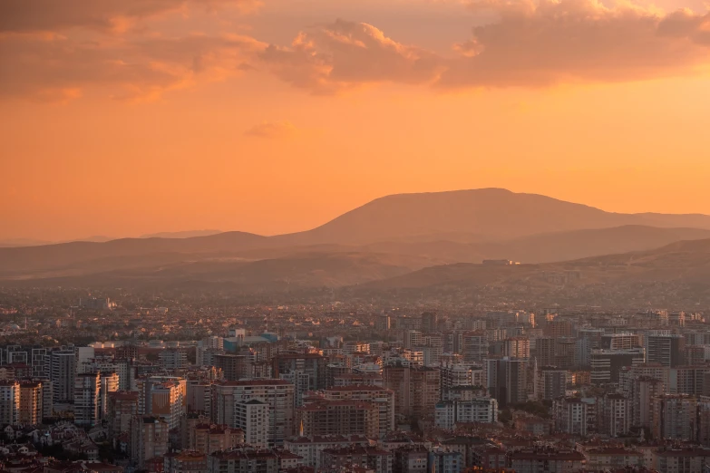 a view of a city with mountains in the background, by Alejandro Obregón, pexels contest winner, sunset panorama, can basdogan, alessio albi, afternoon