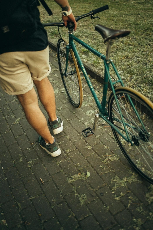 a man riding a bike down a sidewalk, pexels contest winner, khakis, vintage color, very short pants, low detail