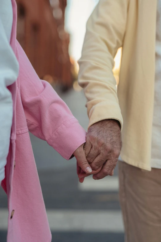 a close up of two people holding hands, by Alison Geissler, coloured photo, paul barson, pink, neighborhood