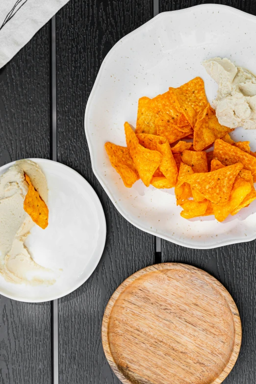 a table topped with plates of food on top of a wooden table, by Carey Morris, unsplash, process art, crisps, white and orange, condorito, detailed product image