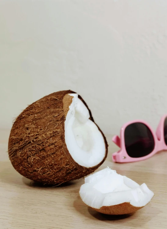 a coconut and a pair of sunglasses on a table, squishy, medium shot angle, detailed product image, recognizable
