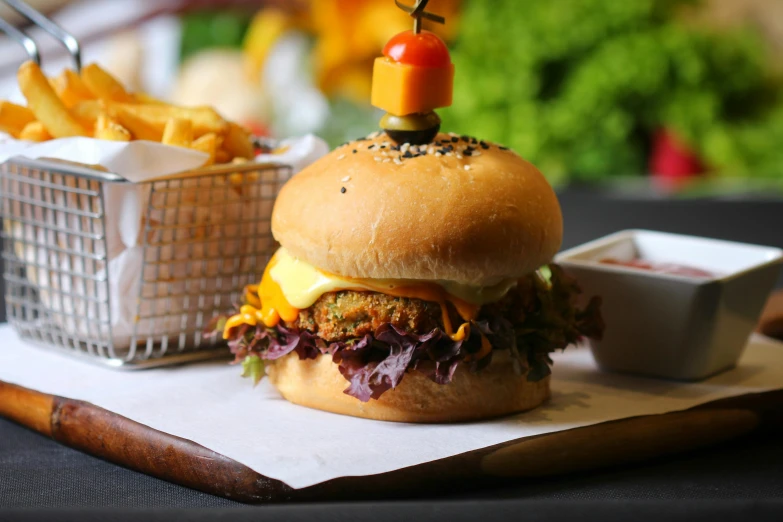 a hamburger sitting on top of a table next to a basket of fries, a portrait, pexels, bangalore, mustard, thumbnail, instagram post