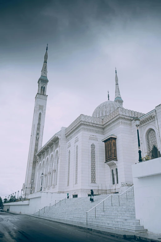 a large white building sitting on the side of a road, inspired by Abdullah Gërguri, trending on unsplash, hurufiyya, minarets, wellington, gray sky, white marble interior photograph