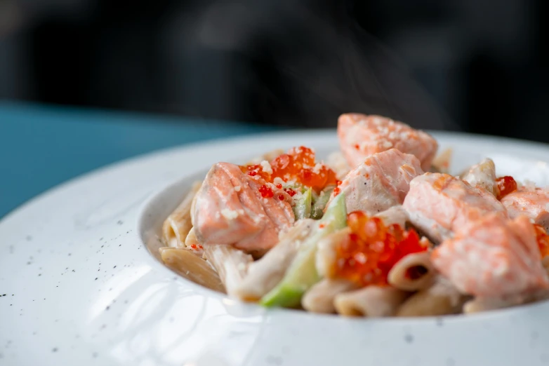 a close up of a plate of food on a table, by Adam Marczyński, salmon khoshroo, pasta, flaming, daily specials
