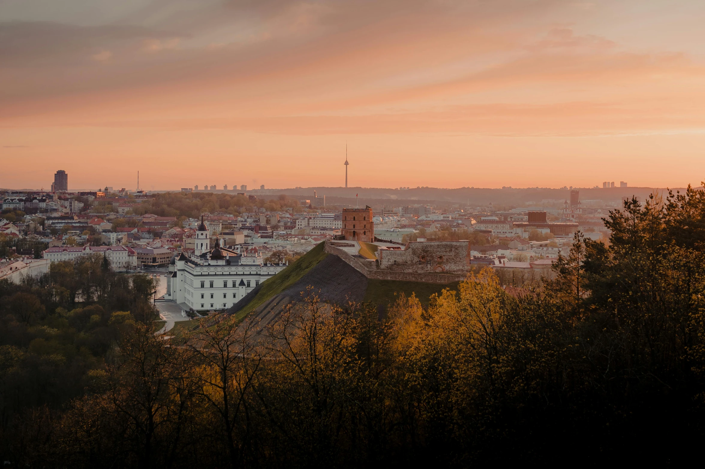 a view of a city from the top of a hill, by Adam Marczyński, pexels contest winner, autumn sunset, capital of estonia, panoramic, fan favorite