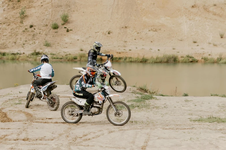 a couple of people that are on dirt bikes, unsplash, figuration libre, river in the background, high quality photo, 000 — википедия, zoomed in shots