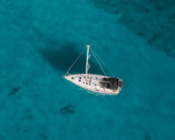 a boat floating in the middle of the ocean, pexels contest winner, looking down on the camera, cerulean, sailpunk, exterior shot