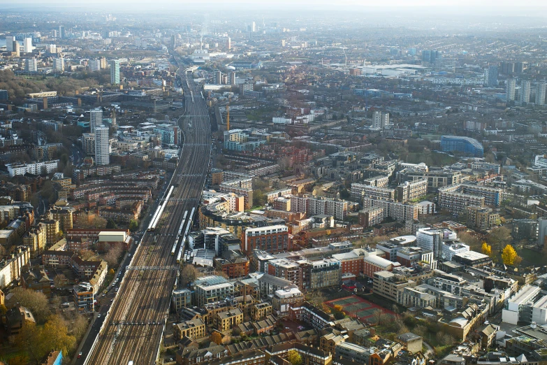 an aerial view of a city with a train on the tracks, unsplash, hurufiyya, london south bank, 4k image”, high resolution ultradetailed, winter sun