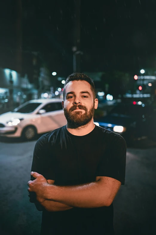 a man standing in a parking lot at night, by Alejandro Obregón, with a beard and a black shirt, kyle hotz, discord profile picture, jen bartel