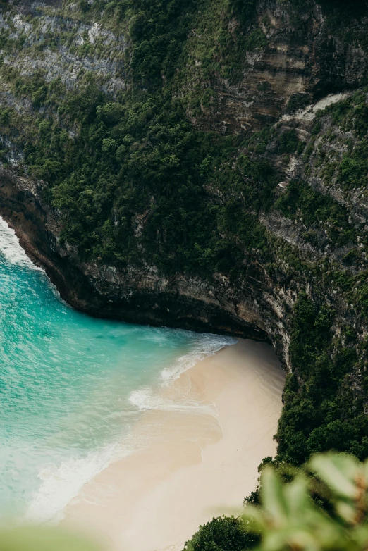 a large body of water next to a lush green hillside, pexels contest winner, sumatraism, beaching, grotto, close-up from above, australian beach