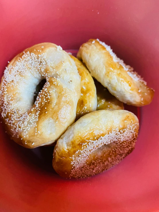 a red bowl filled with donuts covered in sugar, by Kristin Nelson, reddit, hurufiyya, bagels, close up front view, square, 🥥 🍕 hybrid