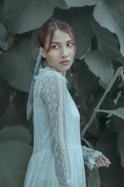 a woman in a white dress standing in front of a tree, inspired by Elsa Bleda, pexels contest winner, renaissance, young asian woman, dressed in a frilly ((lace)), sheer fabrics, girl with a pearl earringl