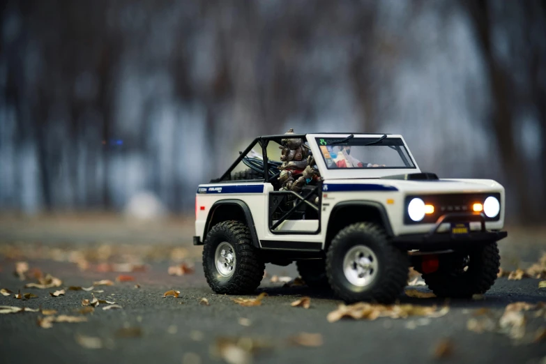 a toy jeep sitting on top of a road, by Sam Havadtoy, unsplash, photorealism, gi joe, high speed chase, 1 / 1 6 th scale, holiday season