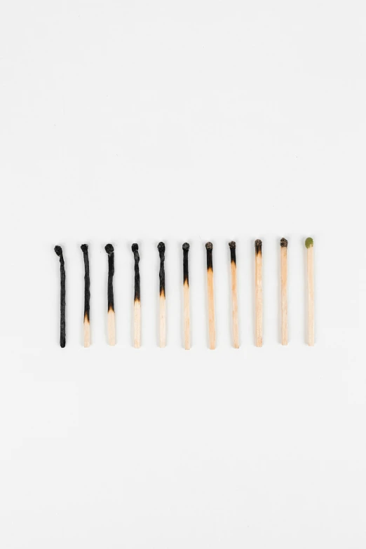 a row of matches on a white background, an album cover, inspired by Suzanne Duchamp-Crotti, auto-destructive art, gradient from green to black, composed of random limbs, unstirred paint, productphoto