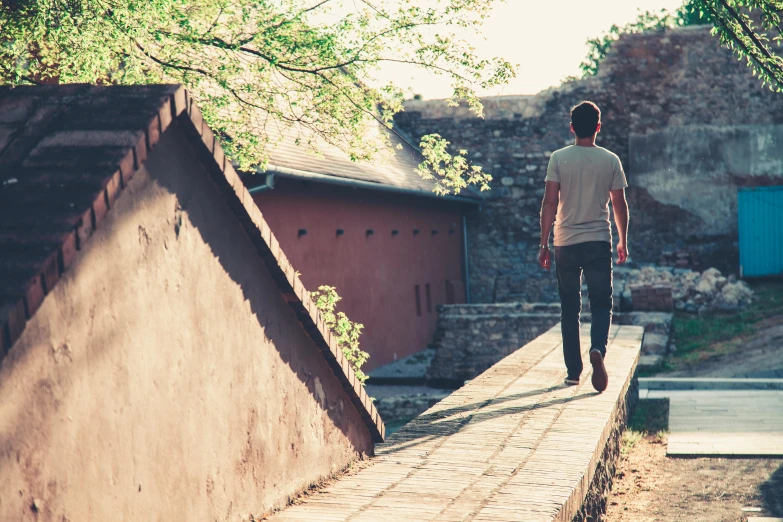 a man riding a skateboard up the side of a ramp, by Jesper Knudsen, pexels contest winner, happening, walking in a castle, ((((dirt brick road)))), vintage vibe, summer light