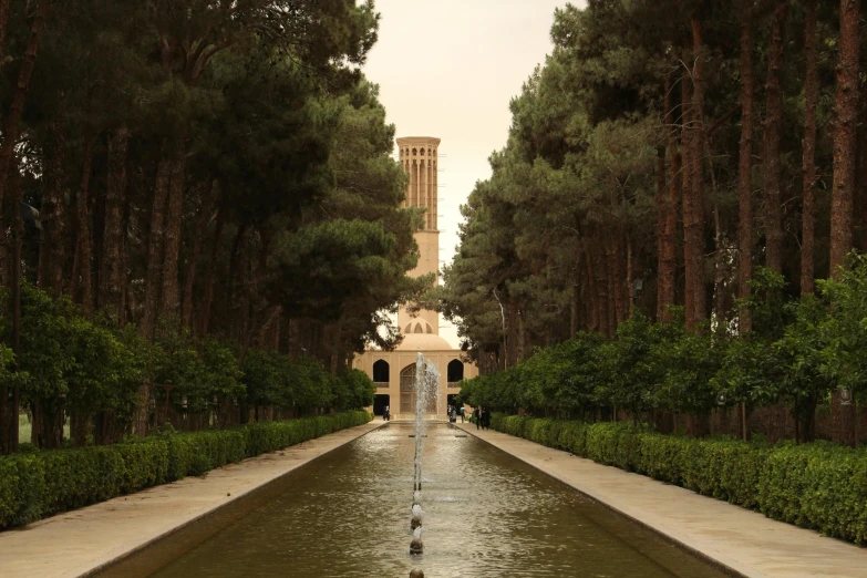 a water fountain with a clock tower in the background, inspired by Ricardo Bofill, unsplash contest winner, tehran, formal gardens, infinitely long corridors, image from afar