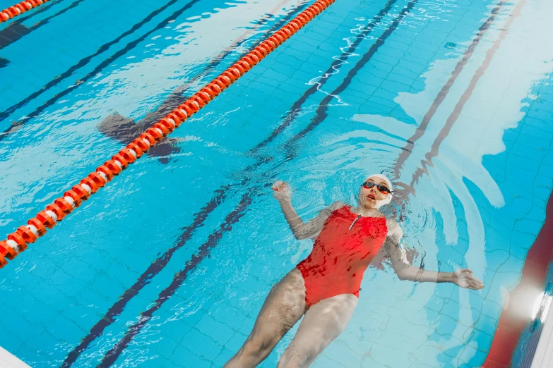 a woman in a red swim suit swimming in a pool, pexels contest winner, lachlan bailey, gofl course and swimming, thumbnail, heavy lines