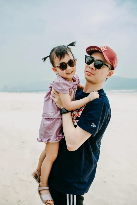 a man holding a little girl on a beach, inspired by Eiichiro Oda, pexels contest winner, dada, wearing sunglasses and a cap, james jean and fenghua zhong, plain background, malaysian