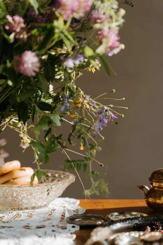 a vase of flowers sitting on top of a table, inspired by Frederick Goodall, trending on unsplash, detail shot, herbs, “ golden chalice, snacks