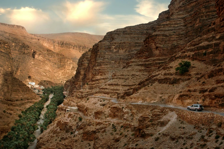 a van parked on the side of a road in a canyon, by Farid Mansour, les nabis, panoramic photography, terraced, brown, islamic