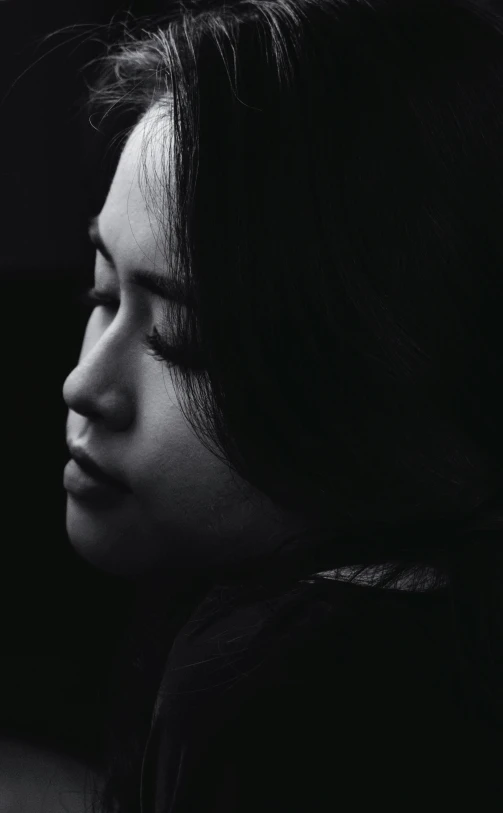 a black and white photo of a woman with her eyes closed, a black and white photo, by Shang Xi, woman's profile, looking sad, high quality photo, album cover art